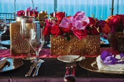Festlich dekorierter Tisch mit Gedecken und Blumengestecke in vergoldeten Gefässen für eine indische Hochzeit