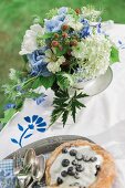 Bouquet of blue and white garden flowers and blueberry tartlet