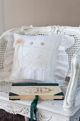 Cushion with white lace cover on antique cane chair