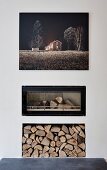 Edited landscape photo on wall above modern fireplace with glass front and firewood niche