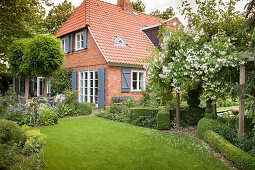 Brick house with shutters in idyllic garden