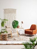 Armchair, designer stool, serving trolley, macrame wall hanging and house plants
