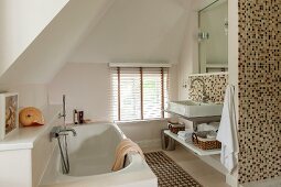 Modernes Bad im Dachgeschoss, Badewanne mit Wandarmatur gegenüber Waschtisch, an Wand Mosaikfliesen in hellen Brauntönen