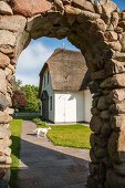 View of holiday home seen through stone archway