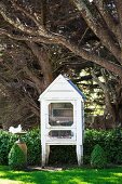 Pigeon house under trees, white pigeon at the bird bath