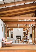 View of wooden terrace and living room with wooden construction and simple Asian flair, father and child on a comfortable armchair