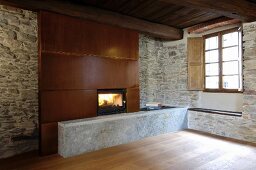 Fireplace with metal chimney break in rustic stone wall