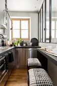 Stainless steel cabinets and bar stools in narrow kitchen