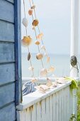 Garland of shells on balcony of wooden seaside cabin