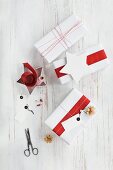 Gifts wrapped in red and white and wrapping materials