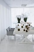 Modern table set for Christmas meal with artificial snow, moss balls and stag candelabra