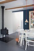 Old iron stove, white furniture and grey floor in dining room