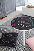 Games table with drawings on chalkboard top on rug with graphic pattern