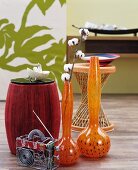 Still-life arrangement of floor vases, stools and wire radio sculpture