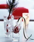 Verzierte Gläser mit Zweig und roter Weihnachtskugel dekoriert