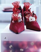 Dunkelrote Wildleder-Damenschuhe gefüllt mit Schokonikolaus und Süßigkeiten