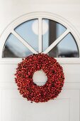 Wreath of red berries below fanlight in front door