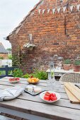 Set table on terrace adjoining brick wall