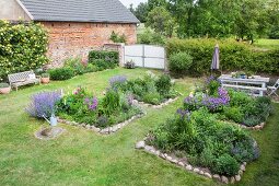 Beds edged with stones in summery cottage garden