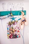 Colourful Christmas gift bag, ballet shoes and headphones hanging from vintage coat rack painted turquoise