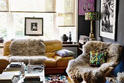 Schaffelle auf Sessel und Sofa in künstlerischem Wohnzimmer