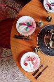 Minimalistisch gedeckter Tisch mit Kreuzmotiven und Namenskärtchen auf Teller