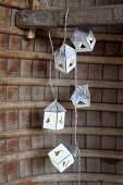 Garland of miniature houses hanging from wooden beam