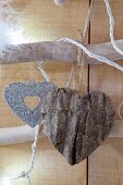 Two hand-made love-heart decorations, one made from bark and one from card and glitter