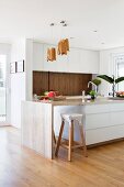 White designer kitchen with island made of natural stone