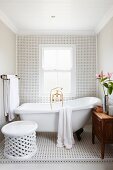 Black and white tiles and free-standing bathtub in simple bathroom