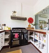 Kitchen with hatch, black gas stove and red wall clock