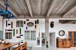 Concrete ceiling, glass wall and eclectic furnishings in loft apartment