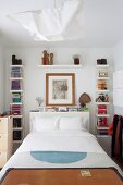 Bookcases around bed headboard in small bedroom