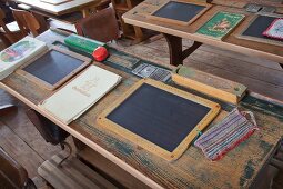 Slates, pencil boxes and hand-sewn wiping cloth on vintage school desk