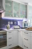 Translucent cupboards and indirect lighting in modern kitchen