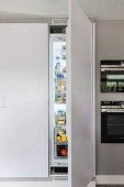 Raumhoher Einbauschrank mit offener Kühlschranktür
