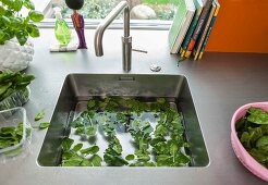 A stainless steel work surface with an integrated sink and washed salad