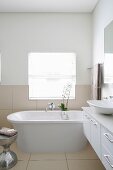 Free-standing bathtub in bright bathroom