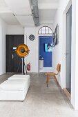 White pouffes and doors in industrial-style foyer