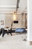 Lounge in industrial-style loft apartment with brick wall and concrete floor