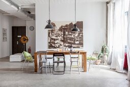 Wooden table, various chairs, large vintage-style photo and view of entrance area