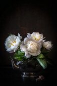 Bouquet of white peonies in silver teacup