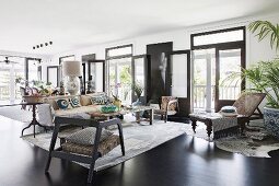 Spacious living room with various seating furniture, French doors and black floor