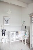 Cot, rabbit toy on stool and classic child's chair in corner of bright room