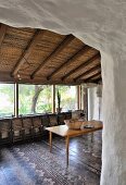 Mediterraner Essbereich mit Holztisch, angelehnten Klappstühlen und traditionellem Fliesenboden
