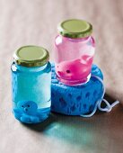 Bubble bath and small rubber animals in screw-top jars