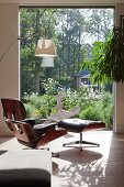 View past designer armchair through window and into garden