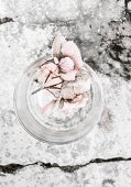 Wasserglas mit verblasster Hortensienblüte auf Steinuntergrund
