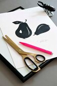 A signed DIY silhouette with a pear design, a pair of scissors and a pink pen