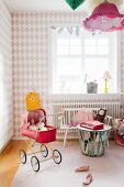 Mädchenzimmer mit Rautenmuster-Tapete und rotem Retro Puppenwagen